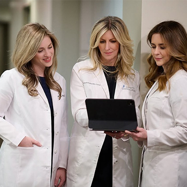 The team at Charlotte Skin & Laser looking at a tablet