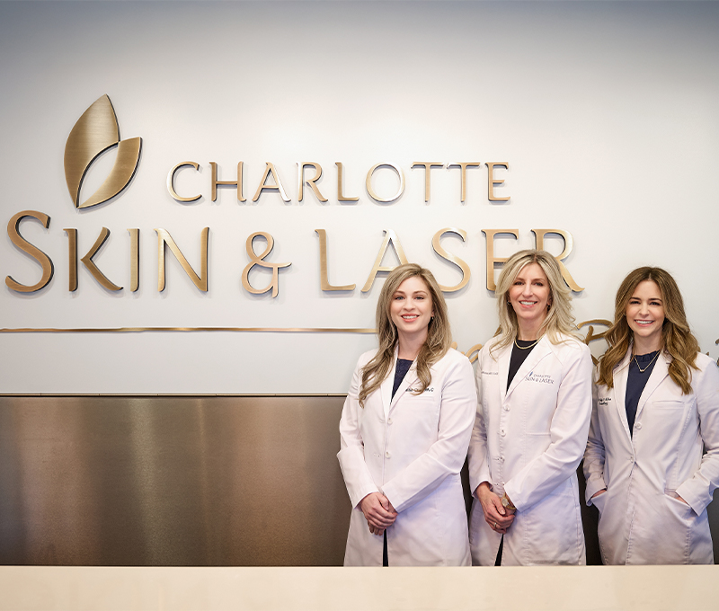 The team of Charlotte Skin & Laser in front of sign